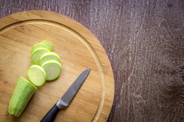 A sliced zucchini on a wooden board. Wooden background