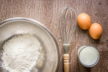 Food ingredients and kitchen utensils for cooking on wooden background