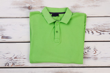Green shirt on wooden background.
