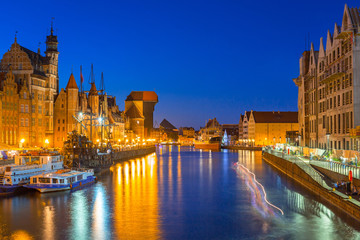 Fototapeta premium Gdansk at night with historic port crane reflected in Motlawa river, Poland