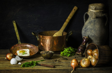 Classic still life with delicious fried egg placed with fresh basil,mixed pepper,onions and old pot on rustic wooden background © dinasaeed