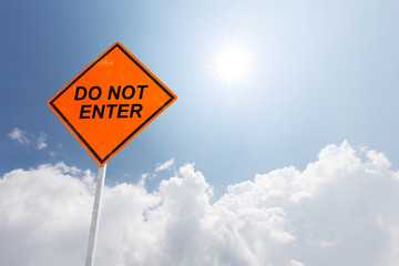 orange diamond traffic sign not enter in blue sunny sky