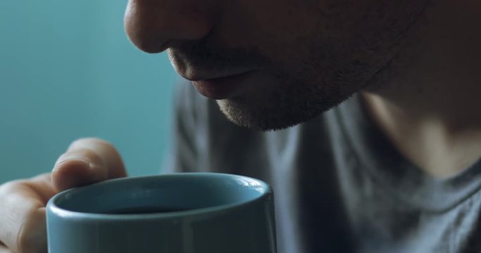 Cropped of man drinking tea at home with original audio