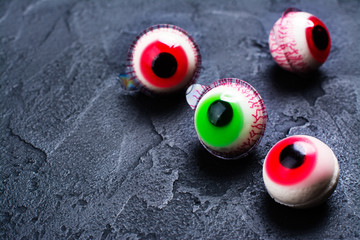 Funny halloween treat - jelly eyeballs on dark background. Copy space