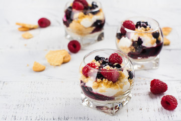 Homemade dessert in glass jars. Cheesecake, trifle, mouse on white wooden background. Copy space