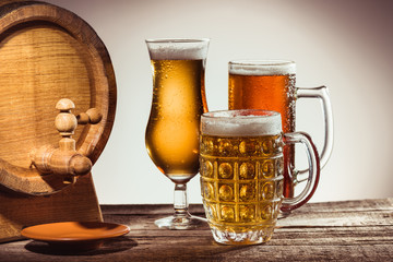 barrel and different beer in glasses