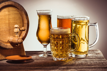 barrel and different beer in glasses