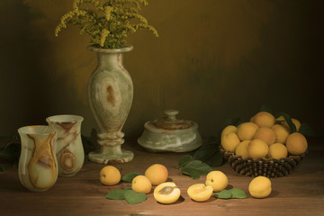 apricots on a green background with a vase