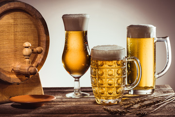 barrel and different beer in glasses