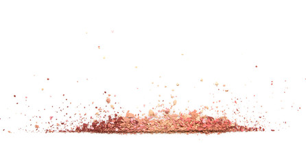 Samples of dry blush, powder, bronzers and highlighter scattered in a line isolated on a white background
