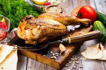 Roasted chicken with pita bread, tomato sauce and fresh raw vegetables on wooden table © happy_lark