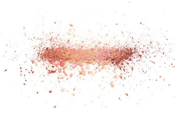 Samples of dry blush, powder, bronzers and highlighter scattered in a line isolated on a white background