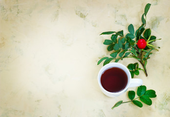 Fototapeta na wymiar Tea from a dogrose in a mug on a light background with fruits