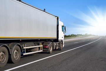 Truck on road with container and bright sun, cargo transportation concept