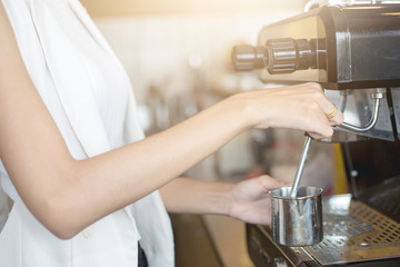 Young Barista girl prepares coffee in the coffee shop or cafe restaurant