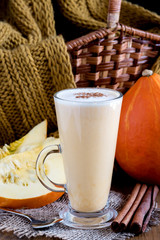 Pumpkin latte with whipped cream and spices on wooden background Vertical 