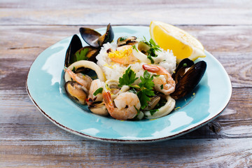 Seafood saute with rice on blue plate. Copy space