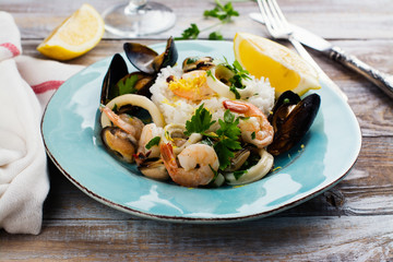 Seafood saute with rice on blue plate. Copy space
