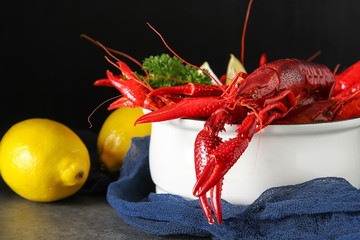 Delicious boiled crayfish close-up with lemon and parsley. Dark 