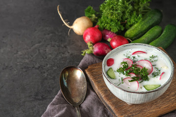 Summer cold soup - okroshka in a ceramic bowl. Ingredients of potatoes, radishes, cucumbers,...