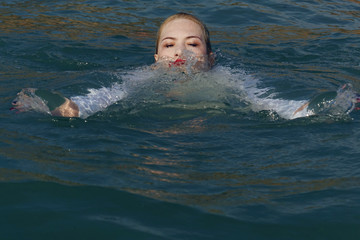 business woman sinking into the sea