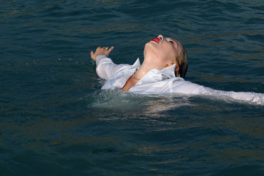 business woman sinking into the sea