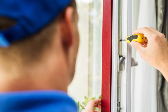 window maintenance service - worker adjusting plastic frame screws