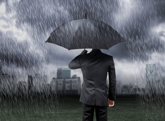 businessman hold umbrella under rain storm with city background