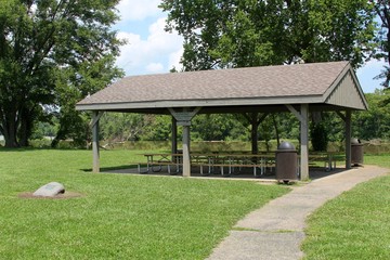 The picnic shelter near the river in the park.