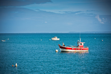 Naklejka premium Bright blue sea and fisherman boats