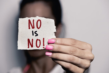 woman showing a note with the text no is no