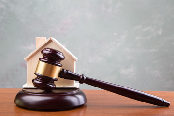 Real estate sale auction concept - gavel and house model on the wooden table