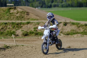 Foto op Canvas kindrijder die offroad op een motorcrossfiets rijdt © dejank1