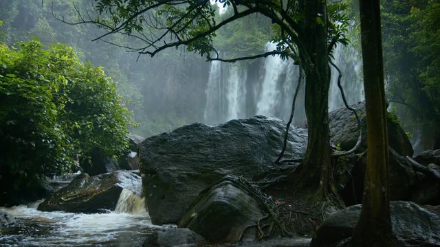 Rainy season in the tropics. Waterfall and a river among rocks and trees
