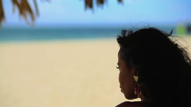 pretty black girl in yellow bikini resting on the  beach