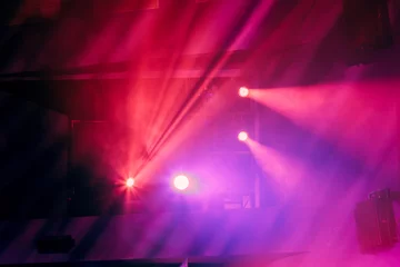 Photo sur Plexiglas Lumière et ombre Matériel d& 39 éclairage sur la scène du théâtre pendant la représentation. Les rayons lumineux du projecteur traversent la fumée. Faisceaux de lumière rouge et violet.