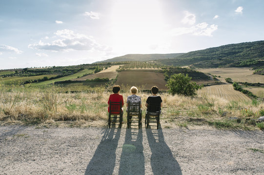 Three women of age advanced with smartphone, in the field