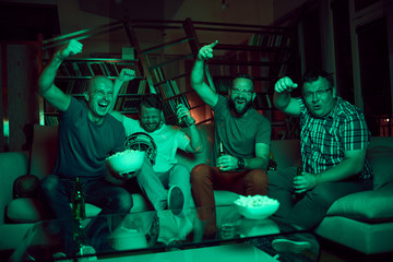 Four men watching american football game on television