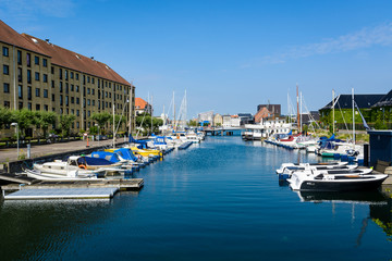 Fototapeta na wymiar Water canal in Copenhagen on a sunny day with plenty of parked boats