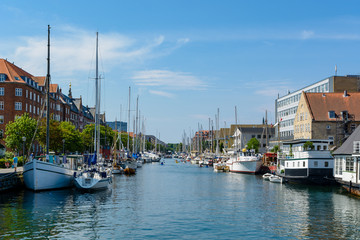 Fototapeta na wymiar Water canal in Copenhagen on a sunny day with plenty of parked boats