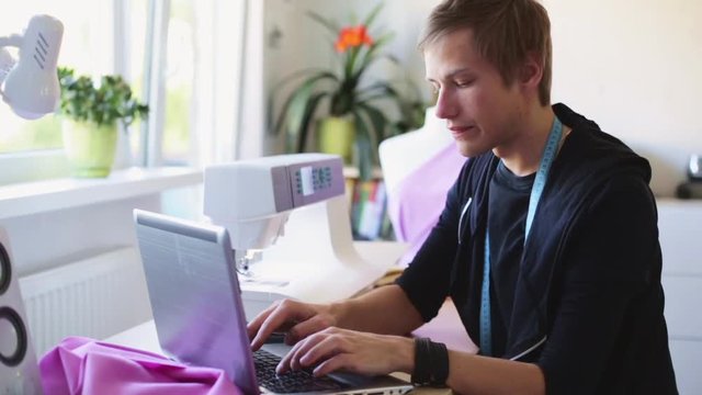 fashion designer with laptop working at studio