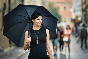 Italian style woman with umbrella in rain