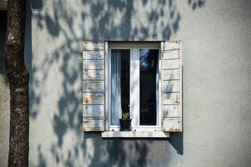 Decorative white window on an a white wooden wall in Italy