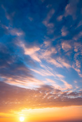 Naklejka na ściany i meble Fantastic sunset blue sky and setting sun and clouds.