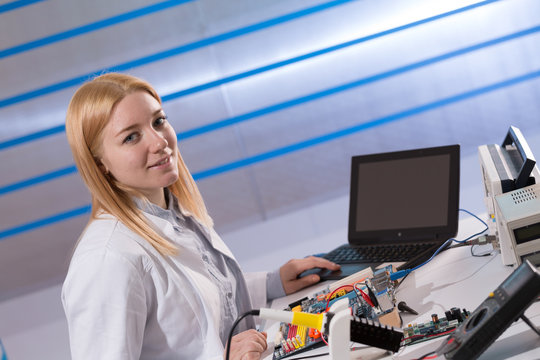 Young woman fix PC component in service center