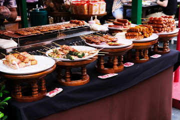 Many kinds of grilled food on white dishes with grilled pork on stove