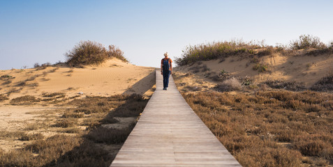 Man traveler with hat and backpack enjoying the natural surroundings.