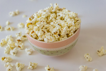 Close-up of  bowl with delicious popcorn on a white background. Concept food by nature.