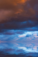 Dramatic clouds in the evening above the calm sea, before a thunderstorm.