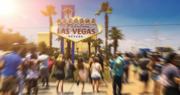 Las Vegas Welcome Sign People Time-Lapse Sun Flare. tourists take photos in front of the famous Las Vegas welcome sign on a hot summer day. Timelapse with motion blur and sun flare
